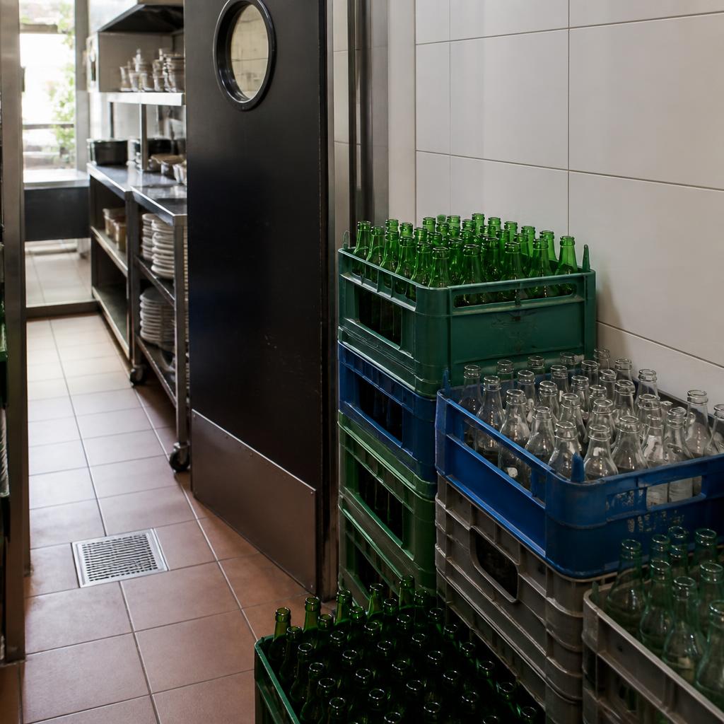 Crates of empty bottles stacked at a restaurant service door